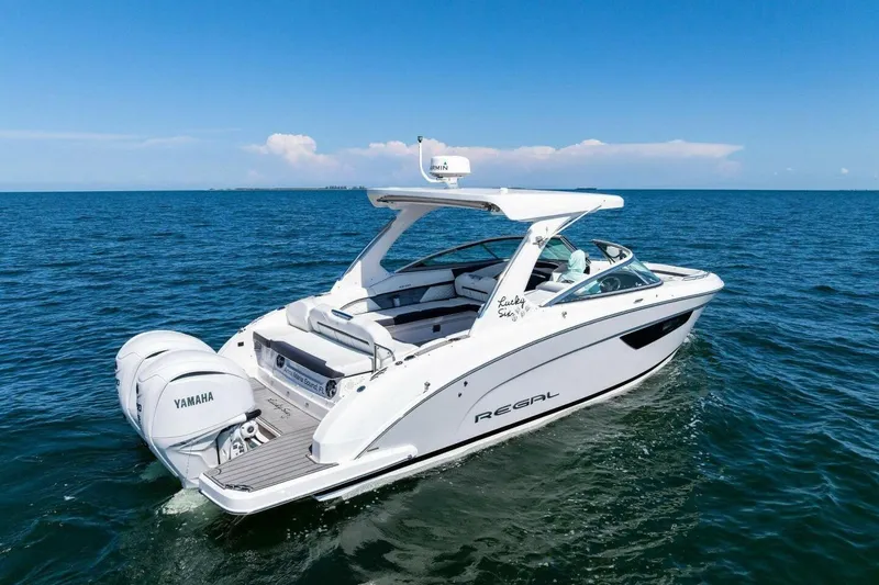 Slide: The Image of 2022 Regal 33 OBX boat cruising on open water with Yamaha engines. - 65