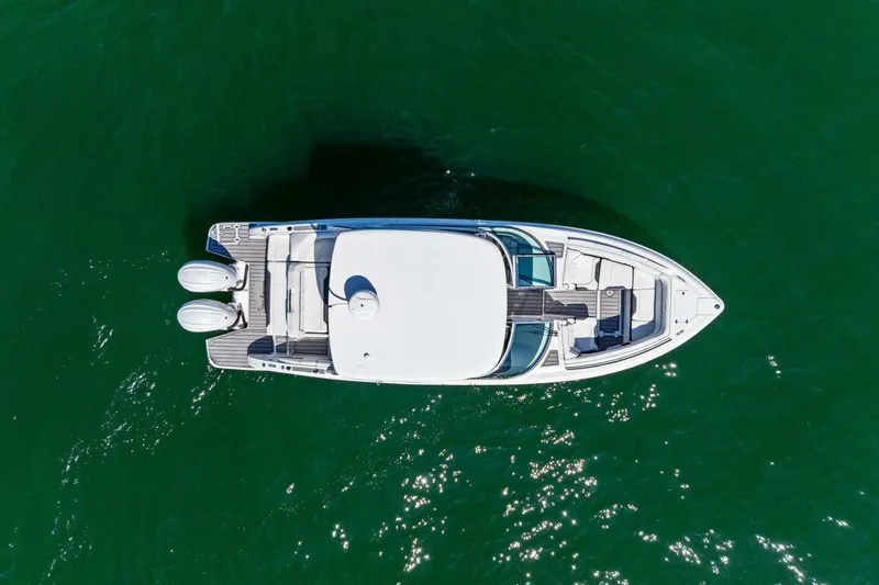 Slide: The Image of Aerial view of 2022 Regal 33 OBX boat on green water. - 67