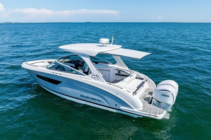Slide: The Image of 2022 Regal 33 OBX boat cruising on open blue water, featuring Yamaha engines. - 73