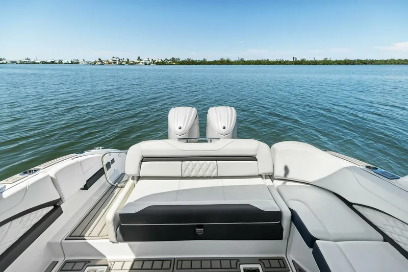 Slide: The Image of 2022 Regal 33 OBX boat interior with luxurious seating, overlooking calm blue waters. - 8