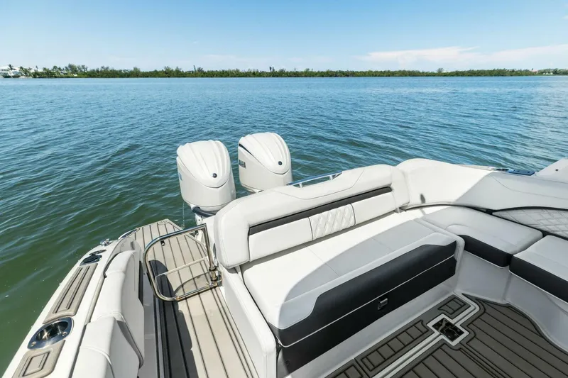 Slide: The Image of 2022 Regal 33 OBX boat with dual engines and luxurious seating on calm water. - 9