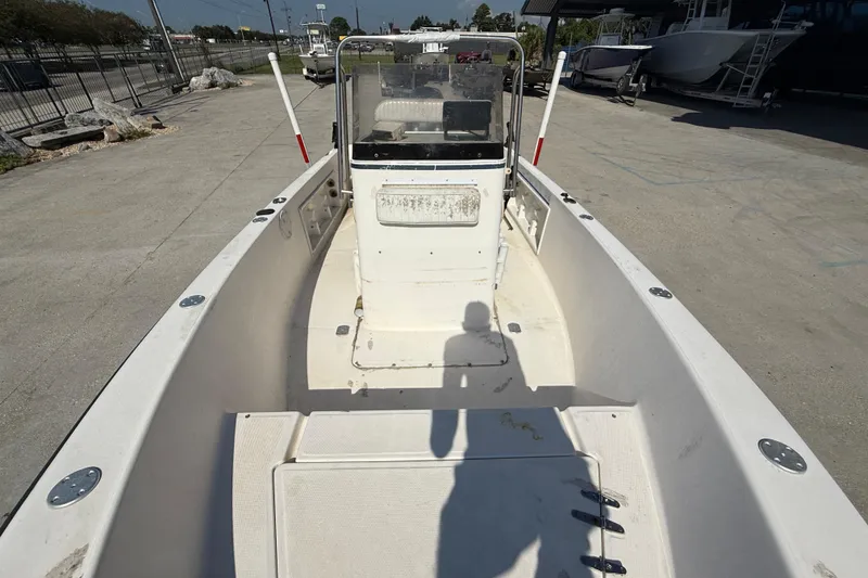 Slide: The Image of 2004 Sea Hunt Triton 186 boat interior, docked, with console and seating area visible. - 10