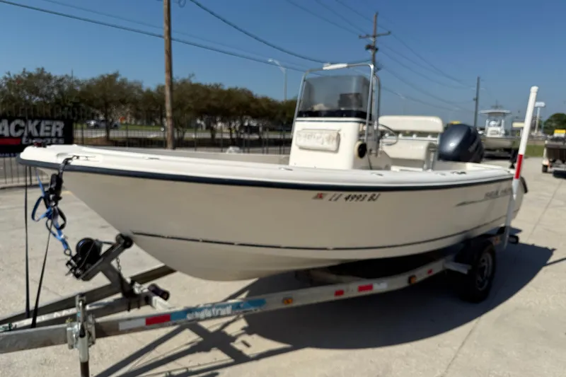 Slide: The Image of 2004 Sea Hunt Triton 186 boat on trailer, parked outdoors under clear sky. - 4