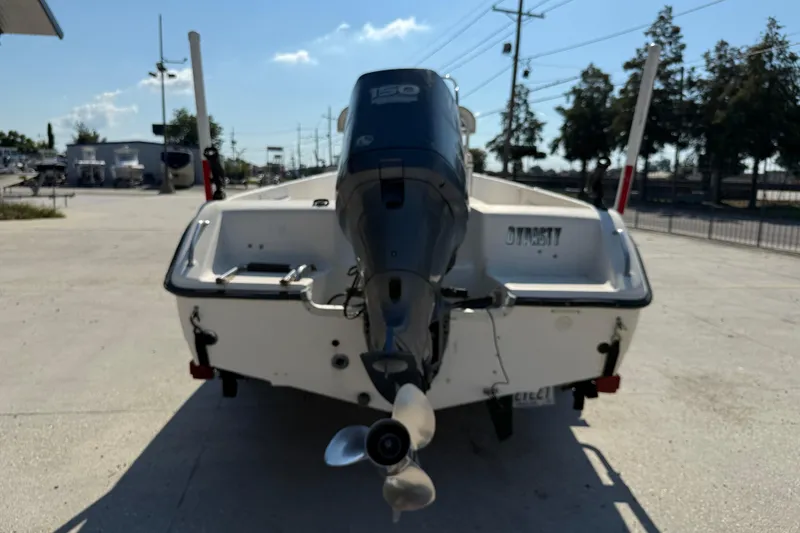 Slide: The Image of 2004 Sea Hunt Triton 186 boat with outboard motor, parked outdoors. - 6