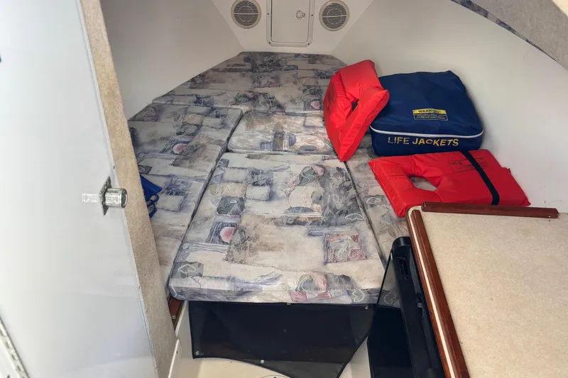 Slide: The Image of Cabin interior of 2000 Shamrock 260 Express with life jackets and patterned bedding. - 10