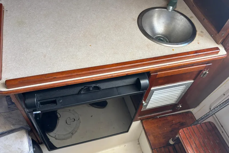 Slide: The Image of Compact kitchenette in 2000 Shamrock 260 Express boat with sink and storage. - 11