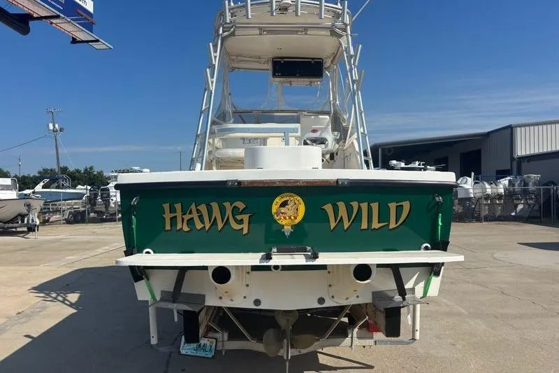 Slide: The Image of Rear view of 2000 Shamrock 260 Express boat named "Hawg Wild" in a marina. - 3
