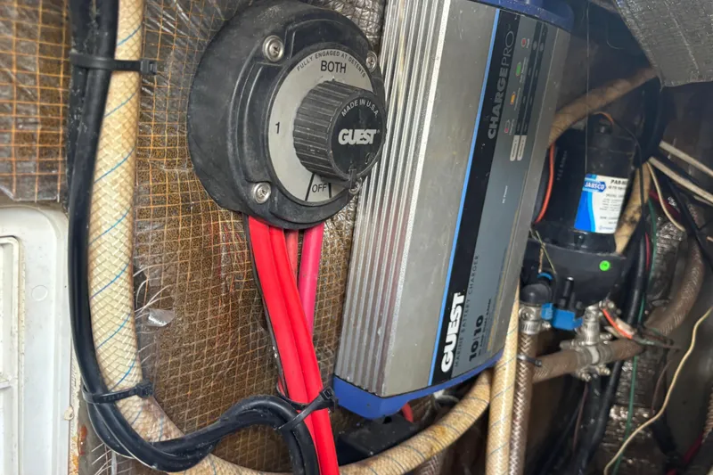 Slide: The Image of Electrical components inside a 2000 Shamrock 260 Express boat, featuring a battery switch and charger. - 32