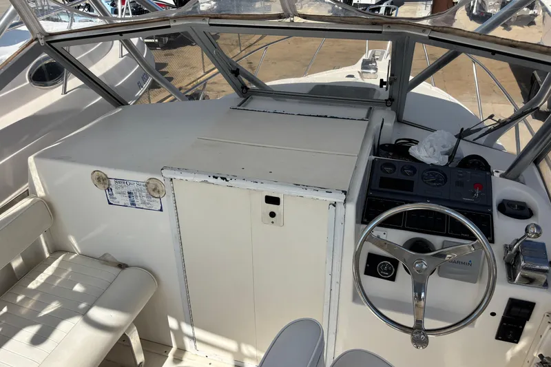 Slide: The Image of 2000 Shamrock 260 Express boat cockpit with steering wheel and control panel. - 42
