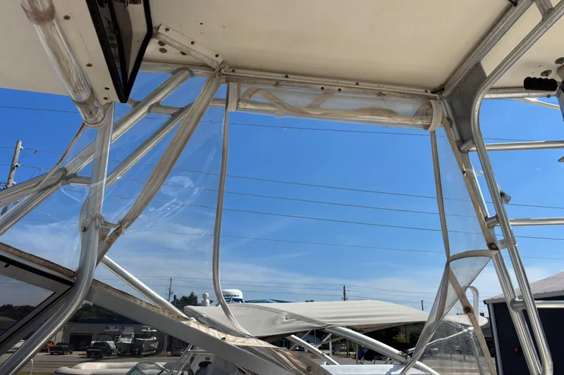 Slide: The Image of 2000 Shamrock 260 Express boat with clear enclosure and metal framework under blue sky. - 44