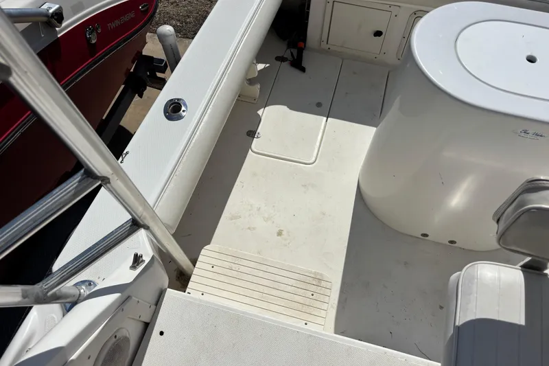 Slide: The Image of Interior view of a 2000 Shamrock 260 Express boat, featuring clean white deck and seating. - 47