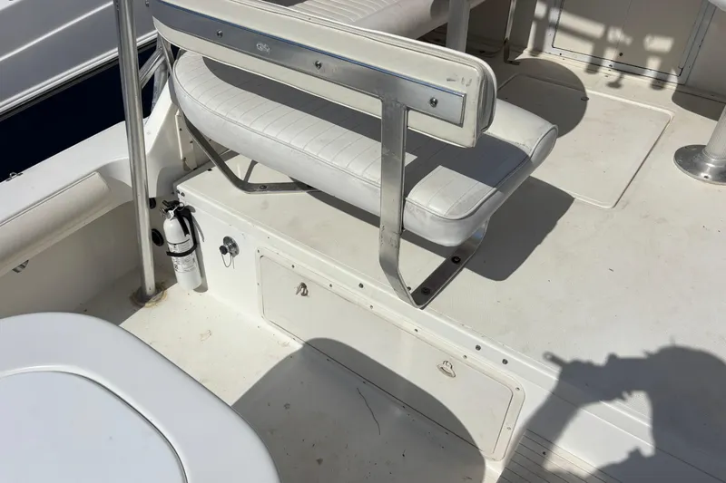 Slide: The Image of 2000 Shamrock 260 Express boat interior with white seating and fire extinguisher. - 56