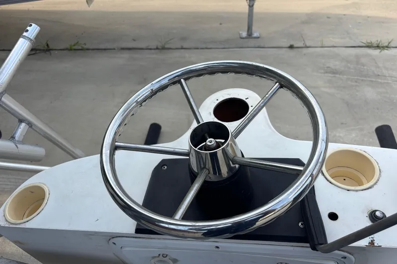 Slide: The Image of Steering wheel of a 2000 Shamrock 260 Express boat, featuring a sleek metal design. - 59