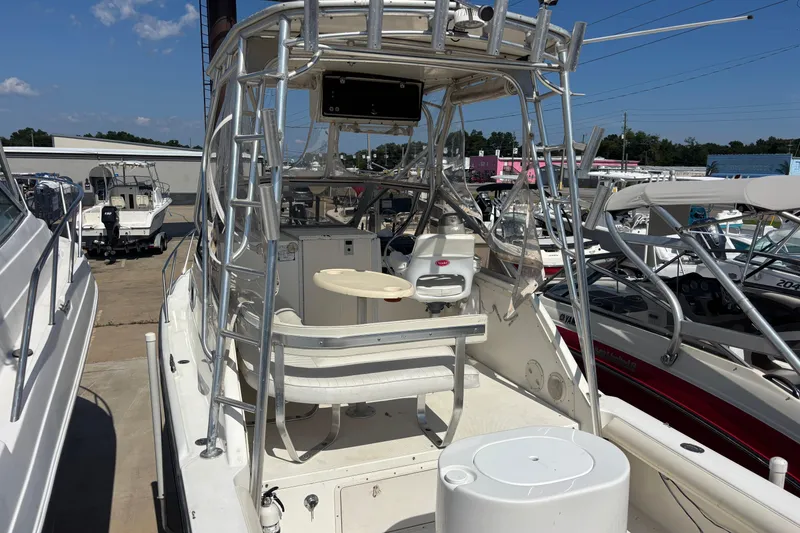 Slide: The Image of 2000 Shamrock 260 Express boat with seating and fishing equipment, docked under clear skies. - 6