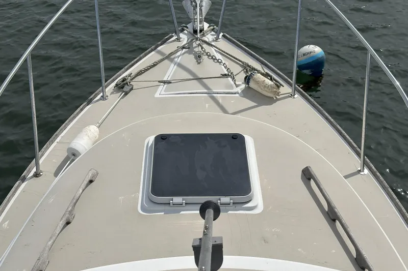 Slide: The Image of 1986 Cape Dory 28 Flybridge boat deck with anchor and buoy on water. - 4