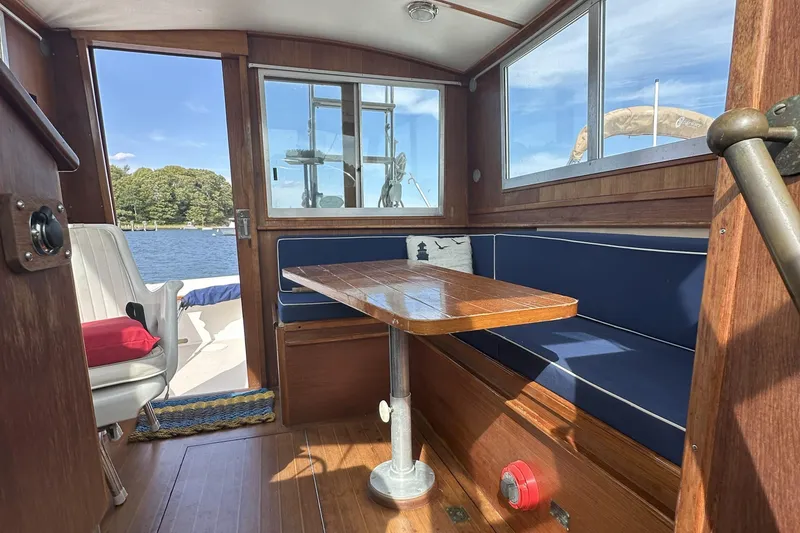 Slide: The Image of Interior of 1986 Cape Dory 28 Flybridge with wooden table and blue seating. - 5