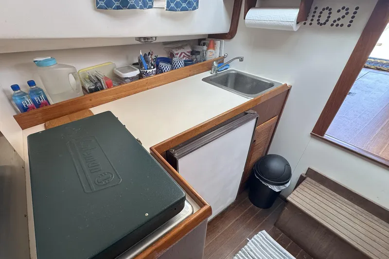 Slide: The Image of Compact kitchen area in a 1986 Cape Dory 28 Flybridge boat with sink and storage. - 7