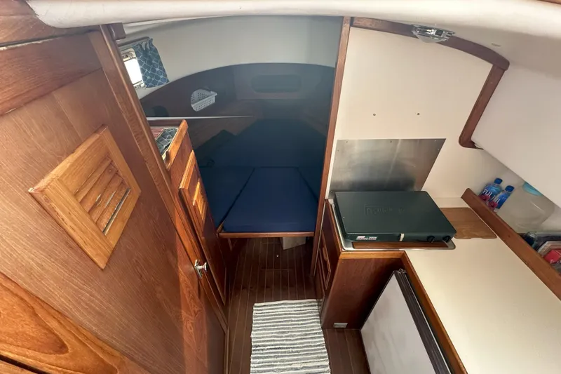 Slide: The Image of 1986 Cape Dory 28 Flybridge interior with wood finish and compact cabin layout. - 8