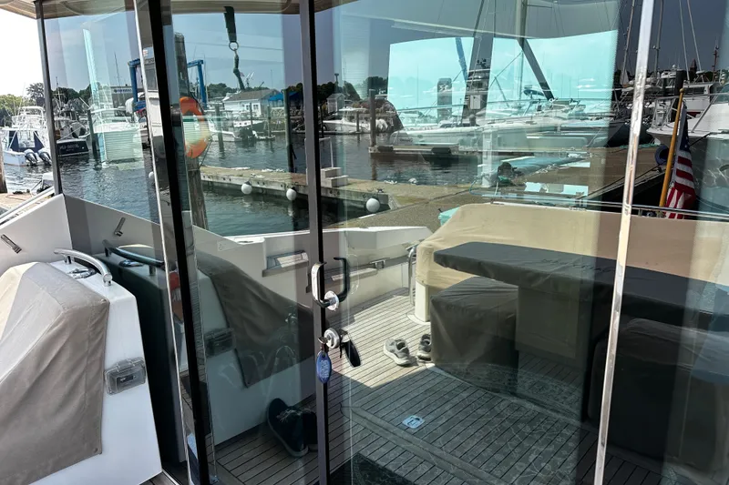 Slide: The Image of 2014 Tiara 5000 Coupe yacht interior with marina view through glass doors. - 11
