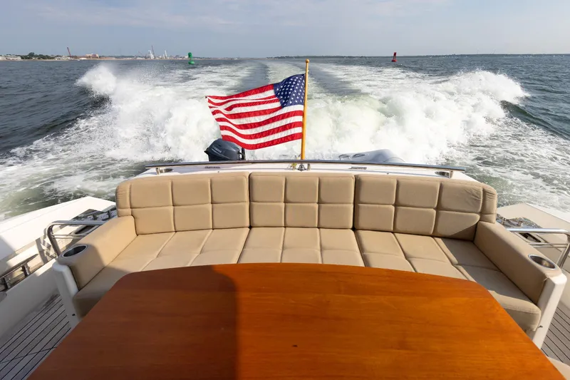 Slide: The Image of 2014 Tiara 5000 Coupe yacht with American flag, cruising on open water. - 4