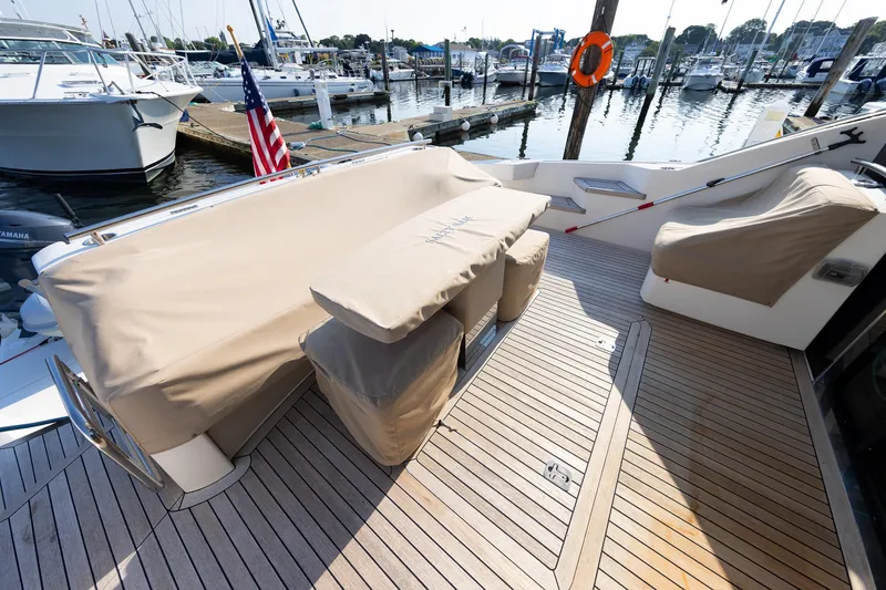 Slide: The Image of 2014 Tiara 5000 Coupe yacht deck with covered seating at marina. - 46