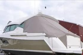 Slide: The Image of 2014 Tiara 5000 Coupe yacht covered, docked near a red building. - 47