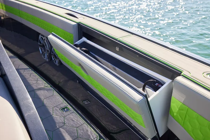 Slide: The Image of Midnight Express 52' Vitesse boat with open storage compartment, green accents, and ocean backdrop. - 12