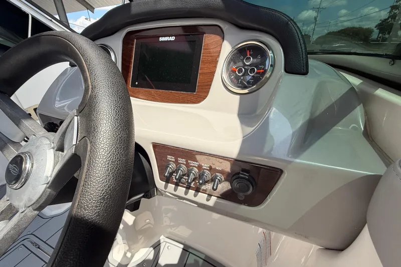 Slide: The Image of 2021 Chaparral 230 SSi boat dashboard with steering wheel and control panel. - 18
