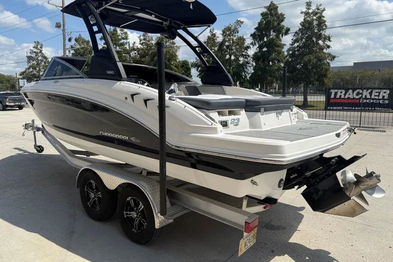 Slide: The Image of 2021 Chaparral 230 SSi boat on trailer, parked outdoors under clear sky. - 5