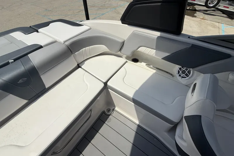 Slide: The Image of 2021 Chaparral 230 SSi boat interior with white and gray seating, speaker, and cup holder. - 13