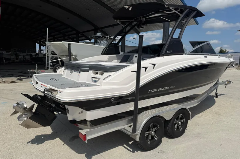 Slide: The Image of 2021 Chaparral 230 SSi boat on trailer, parked outdoors under a clear sky. - 7