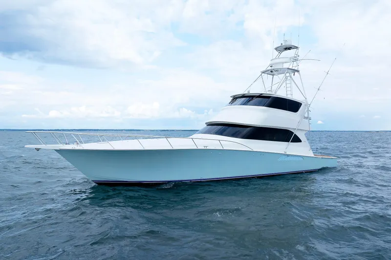 Slide: The Image of 2009 Viking 74 Enclosed Bridge yacht on open water under a cloudy sky. - 11