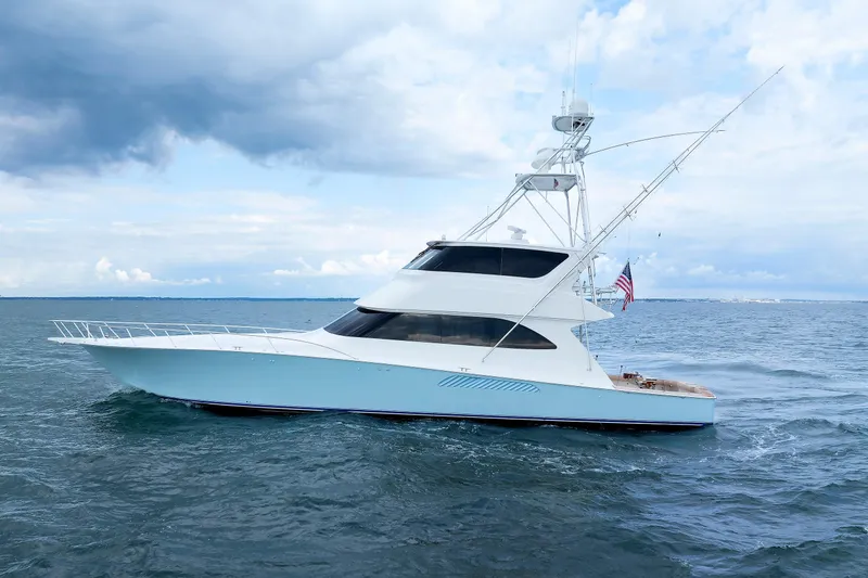 Slide: The Image of 2009 Viking 74 Enclosed Bridge yacht cruising on open water under cloudy skies. - 12