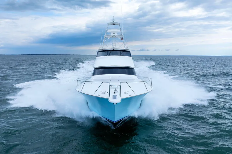 Slide: The Image of 2009 Viking 74 Enclosed Bridge yacht cruising on open sea under cloudy sky. - 26
