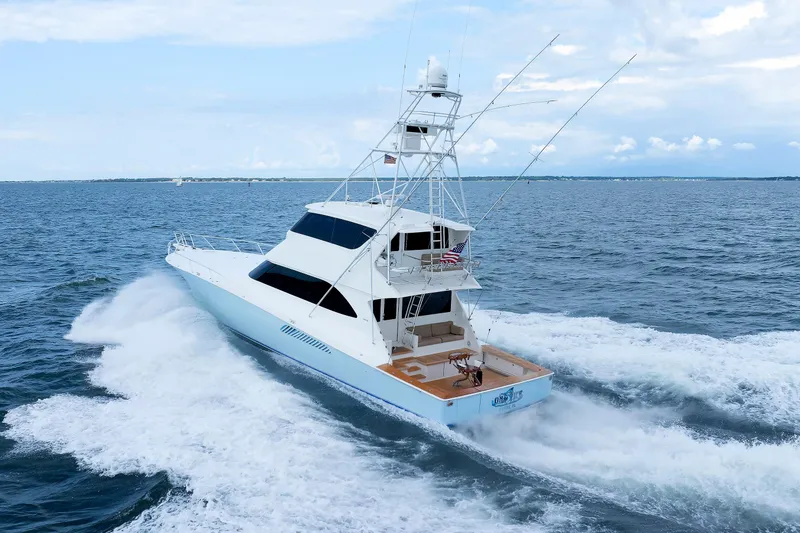 Slide: The Image of 2009 Viking 74 Enclosed Bridge yacht cruising on open sea under clear skies. - 30