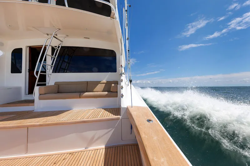 Slide: The Image of 2009 Viking 74 Enclosed Bridge yacht cruising on open sea under clear blue sky. - 48