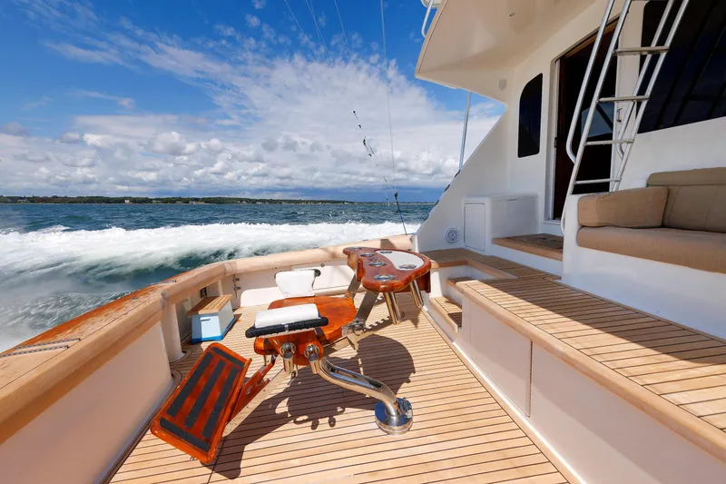 Slide: The Image of 2009 Viking 74 Enclosed Bridge yacht deck with fishing chair, ocean view, and clear sky. - 49