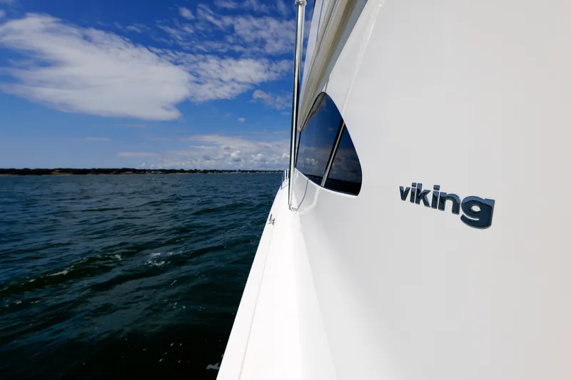 Slide: The Image of Side view of 2009 Viking 74 Enclosed Bridge yacht on open water. - 53