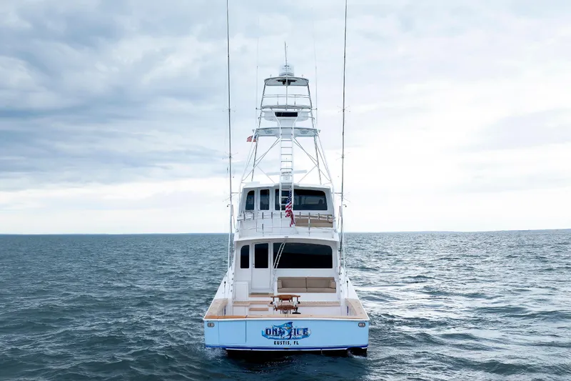 Slide: The Image of 2009 Viking 74 Enclosed Bridge yacht on open sea under cloudy sky. - 6