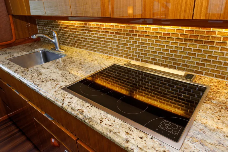 Slide: The Image of Luxurious kitchen in 2009 Viking 74 Enclosed Bridge yacht with granite countertops and modern appliances. - 75