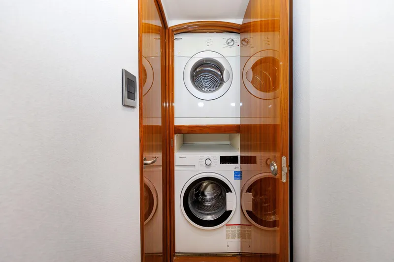Slide: The Image of Laundry area with stacked washer and dryer in 2009 Viking 74 Enclosed Bridge yacht. - 78