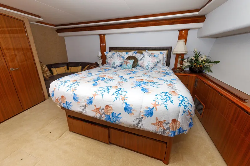 Slide: The Image of Luxurious bedroom in 2009 Viking 74 Enclosed Bridge yacht with nautical-themed bedding. - 82