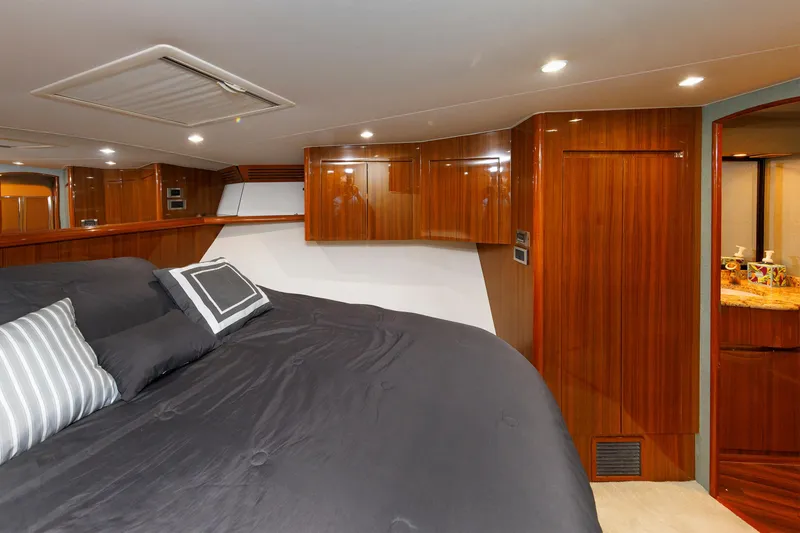 Slide: The Image of Luxurious bedroom interior of 2009 Viking 74 Enclosed Bridge yacht with wood paneling. - 86