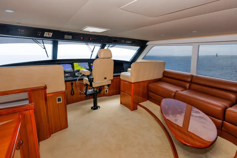 Slide: The Image of Luxurious interior of 2009 Viking 74 Enclosed Bridge yacht with leather seating and navigation controls. - 92