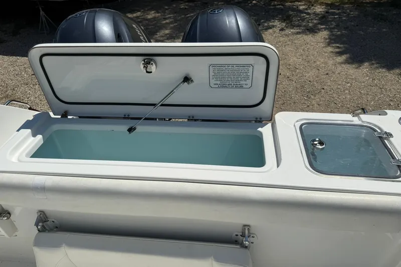 Slide: The Image of 2015 Sea Hunt Gamefish 27 boat with open storage compartment and dual engines. - 12