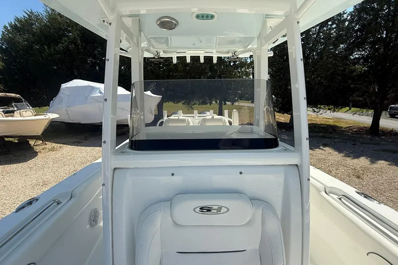 Slide: The Image of 2015 Sea Hunt Gamefish 27 boat interior with console and seating, parked outdoors. - 19