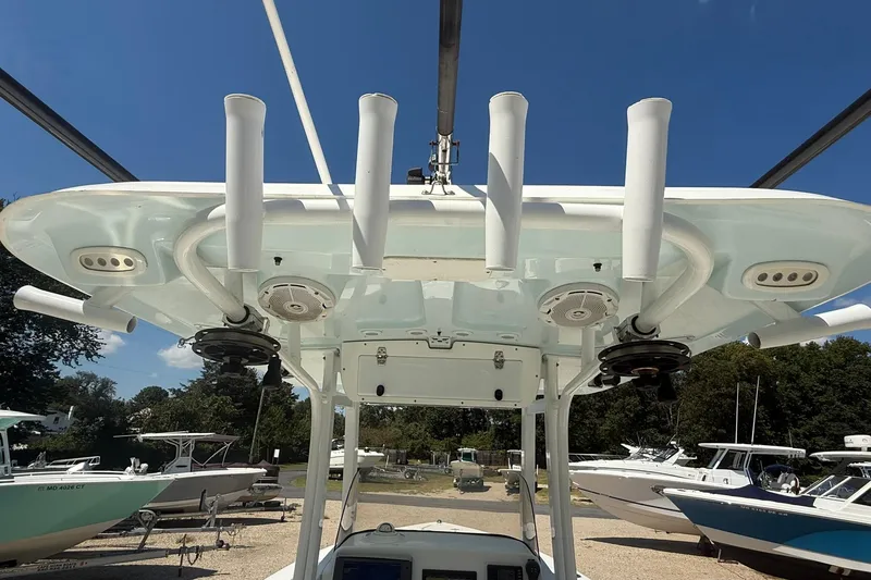Slide: The Image of 2015 Sea Hunt Gamefish 27 boat with rod holders and speakers, docked under clear blue sky. - 22