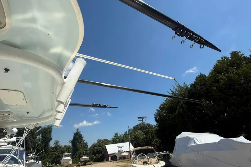 Slide: The Image of 2015 Sea Hunt Gamefish 27 with outriggers, parked outdoors under a clear blue sky. - 29