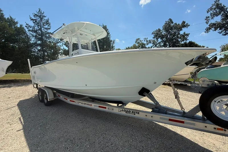 Slide: The Image of 2015 Sea Hunt Gamefish 27 boat on trailer, parked outdoors under clear sky. - 3