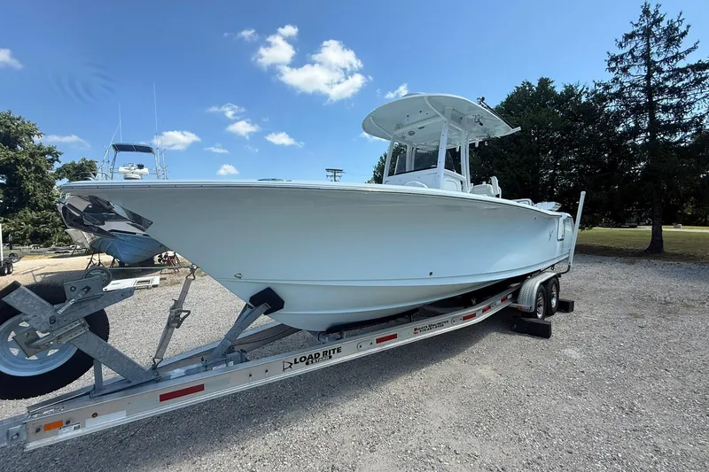 Slide: The Image of 2015 Sea Hunt Gamefish 27 boat on trailer under clear blue sky. - 5